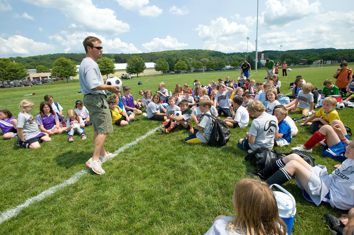 ɫTV’s head soccer coach speaks to participants of a youth soccer camp on the university’s campus.